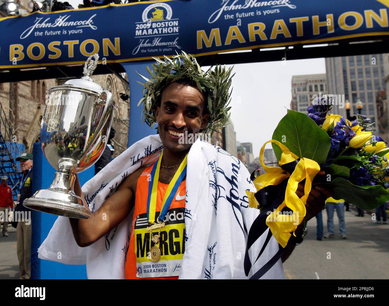 Mens winner Deriba Merga of Ethiopia holds his trophy at the finish