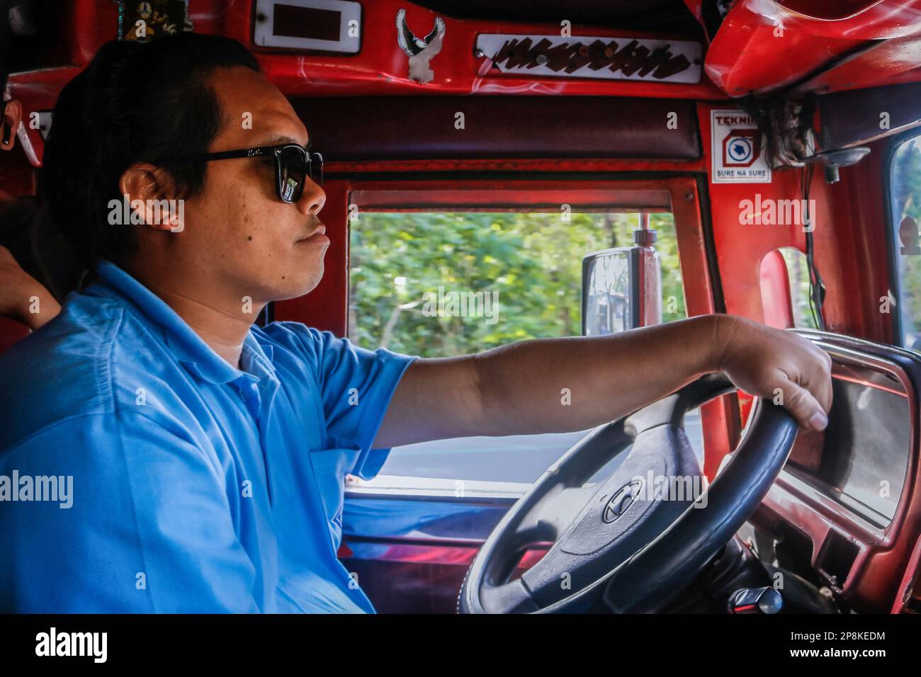 Mark, a jeepney driver, drives a traditional jeepney to transit