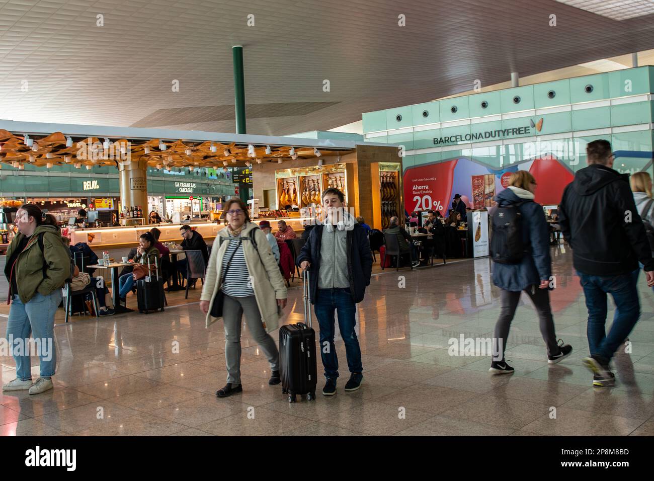 Barcelona,Spain- February 24,2023:People walk in the airport concourse between flights Stock Photo