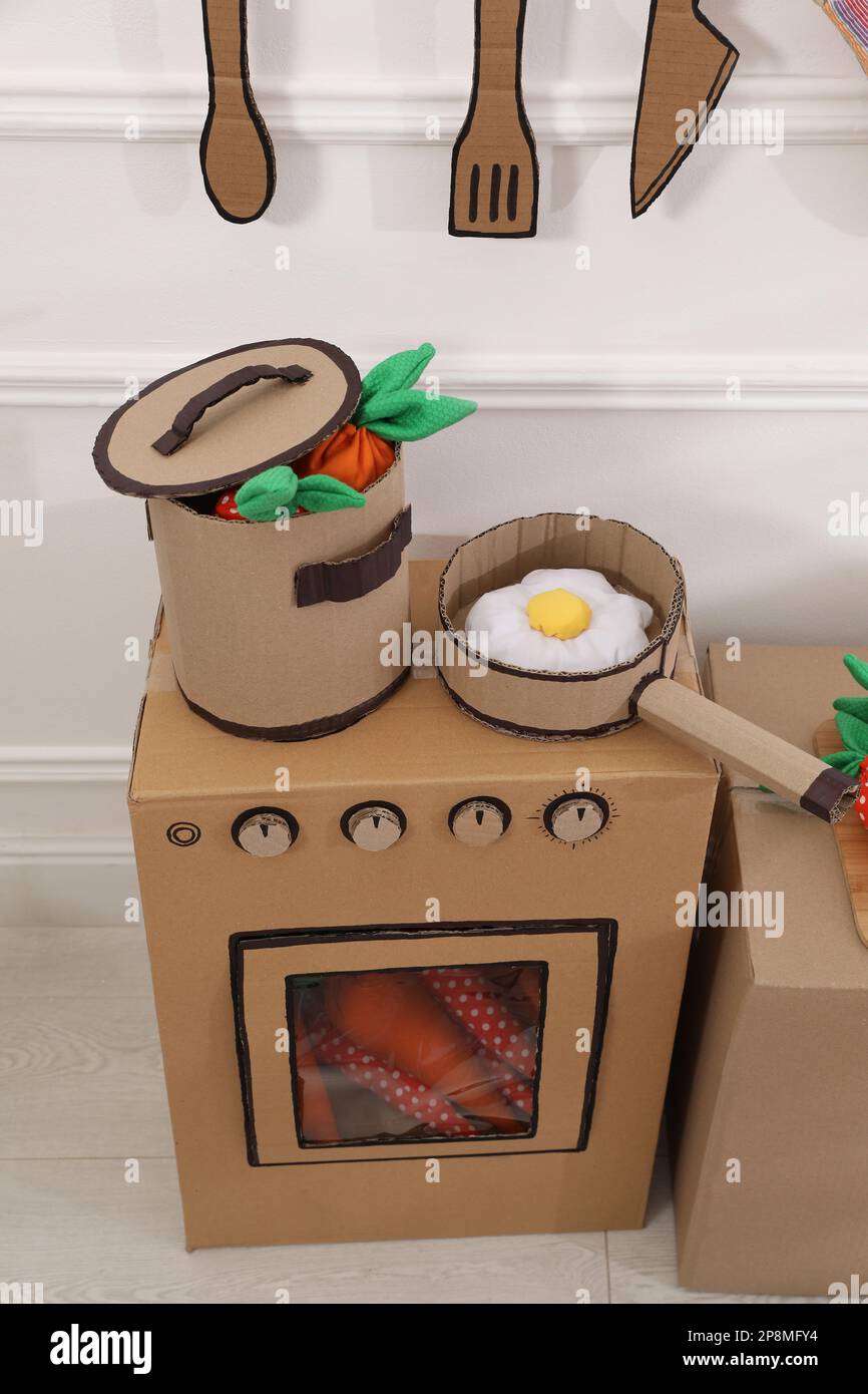 Toy cardboard kitchen with stove and utensils at home Stock Photo Alamy