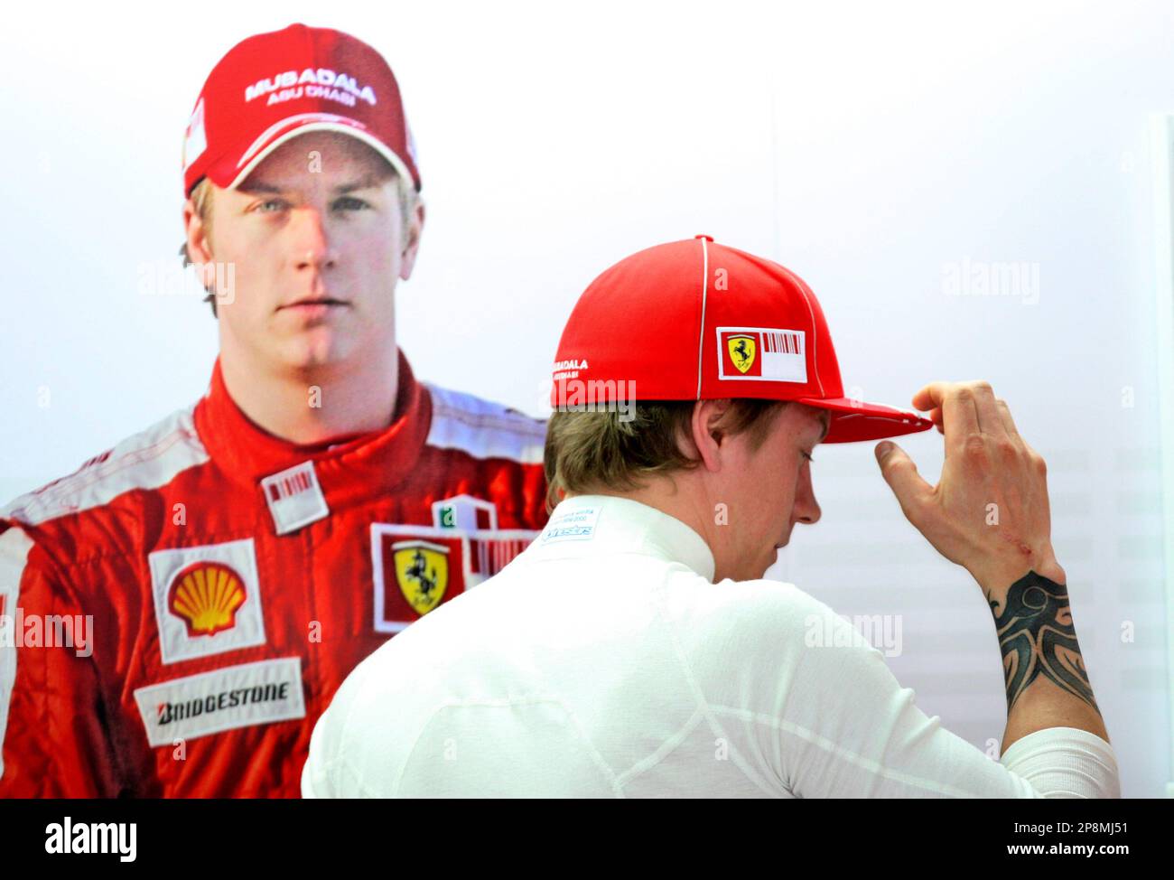 Ferrari Formula One driver Kimi Raikkonen of Finland puts his cap on at his  team garage during the first practice session in Sepang racetrack, outside  Kuala Lumpur, Malaysia, Friday, April 3, 2009.