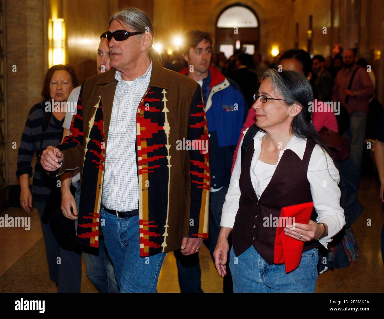Ward Churchill, who was a tenured professor of ethnic studies at the University of Colorado in Boulder, Colo., left, walks with his wife, Natsu Saito, and his supporters after a jury ruled that the professor was wrongly fired by school administrators, Thursday, April 2, 2009 in Denver.. Churchill maintained that he was dismissed in retaliation for his comments about victims of the Sept. 11, 2001, attack on the United States. (AP Photo/David Zalubowski) Stock Photo