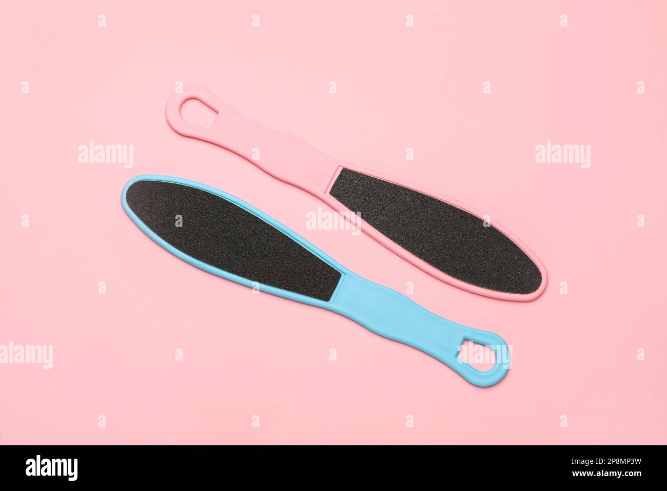 Colorful foot files on pink background, flat lay. Pedicure tools Stock