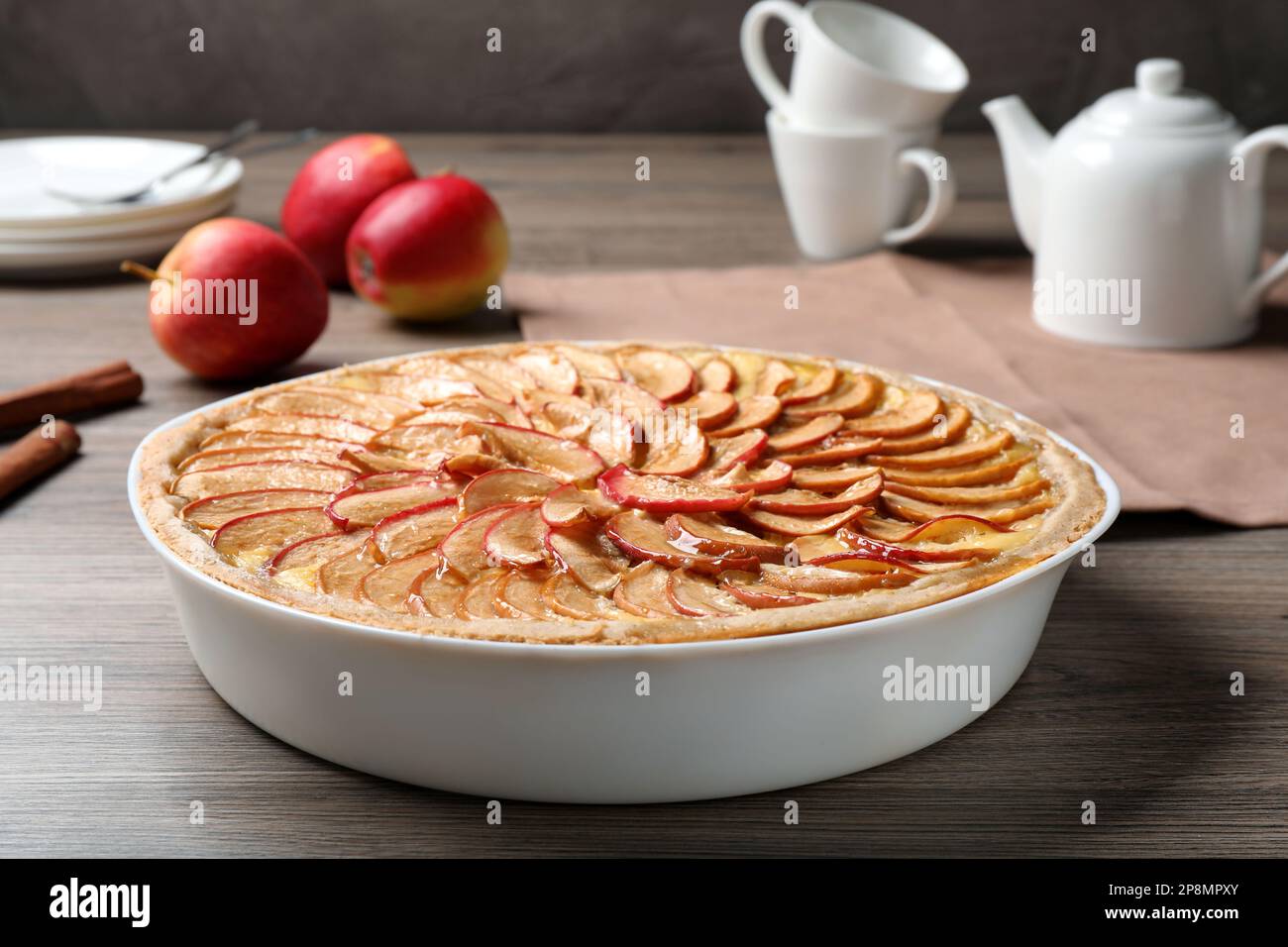 Tasty apple pie in baking dish on wooden table Stock Photo
