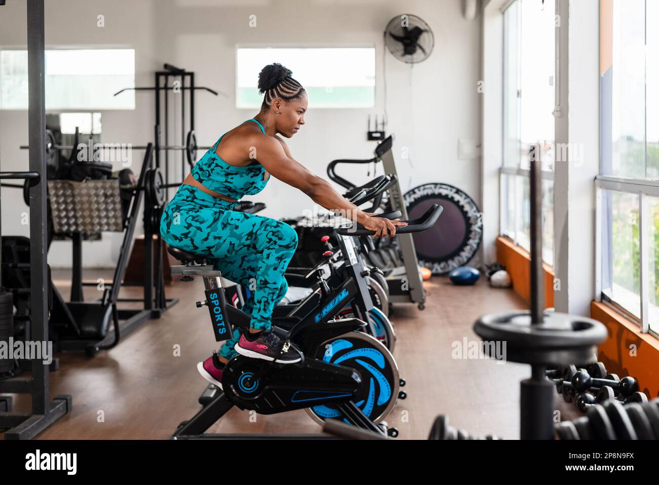 Pretty girl doing exercise on exercise bike. crossfit gym. Cycling Stock Photo - Alamy