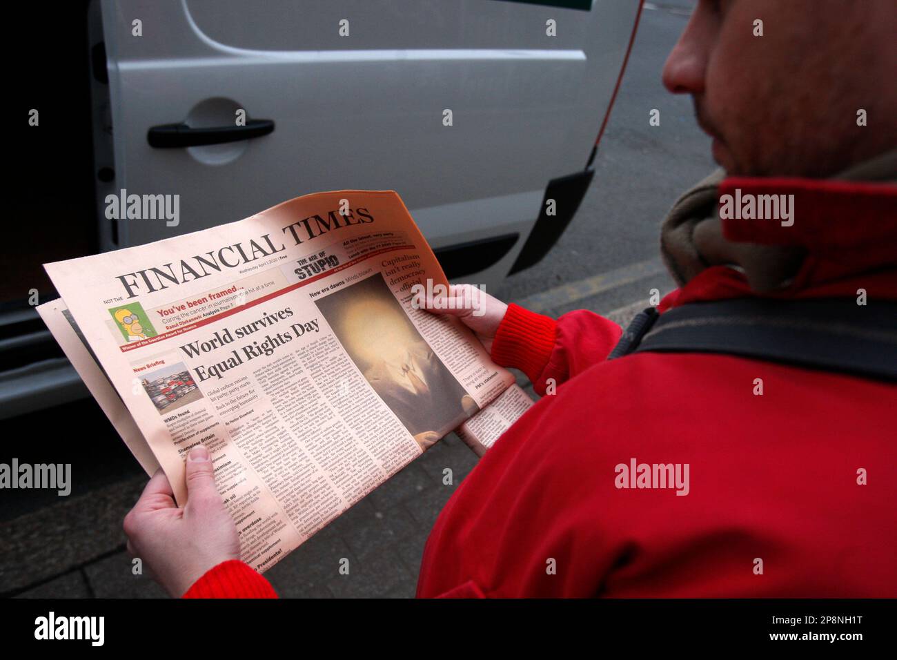 A man reads a copy of a spoof edition of Britain's Financial Times ...