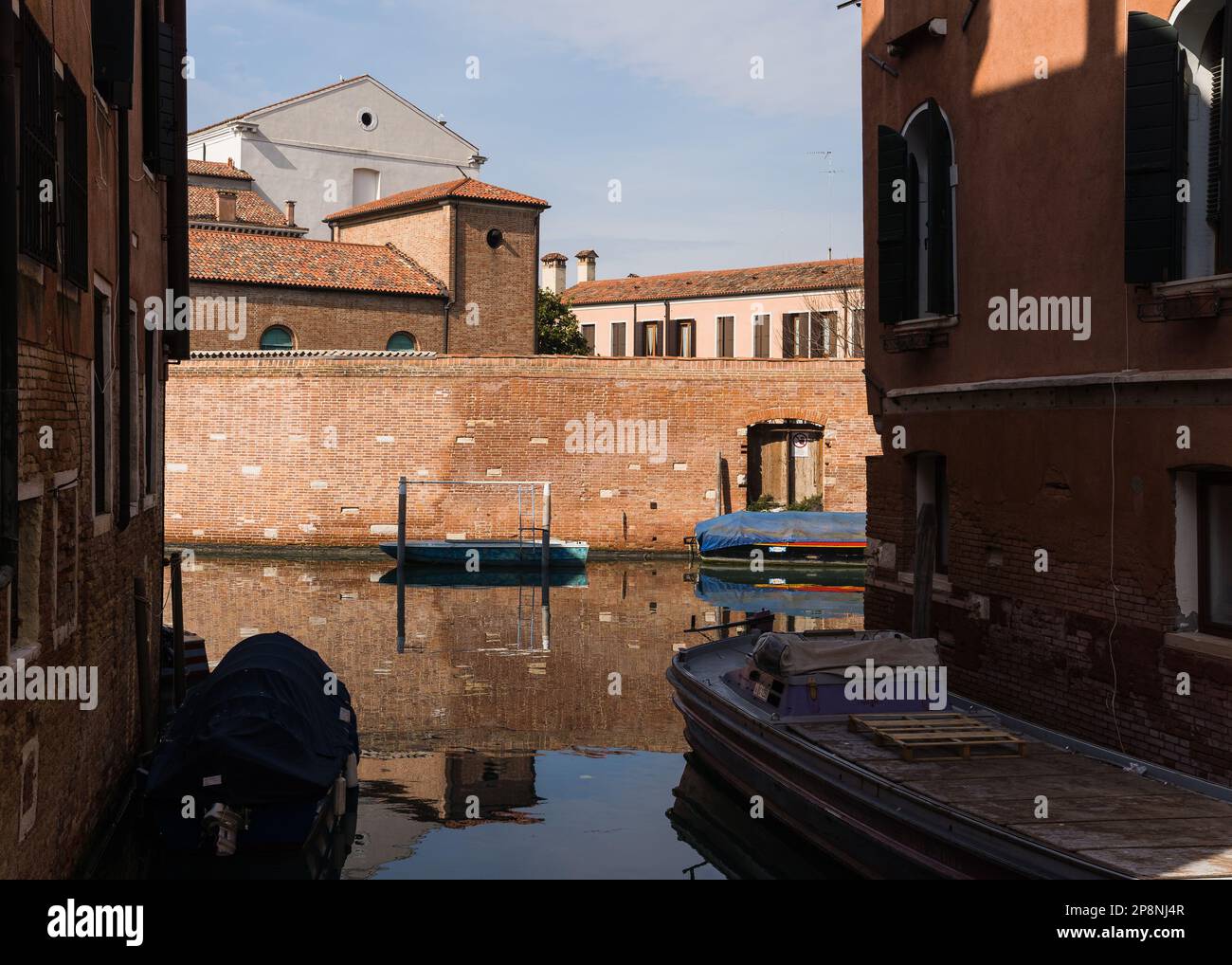 Brick wall and water reflection on canal in Venice, Italy Stock Photo ...