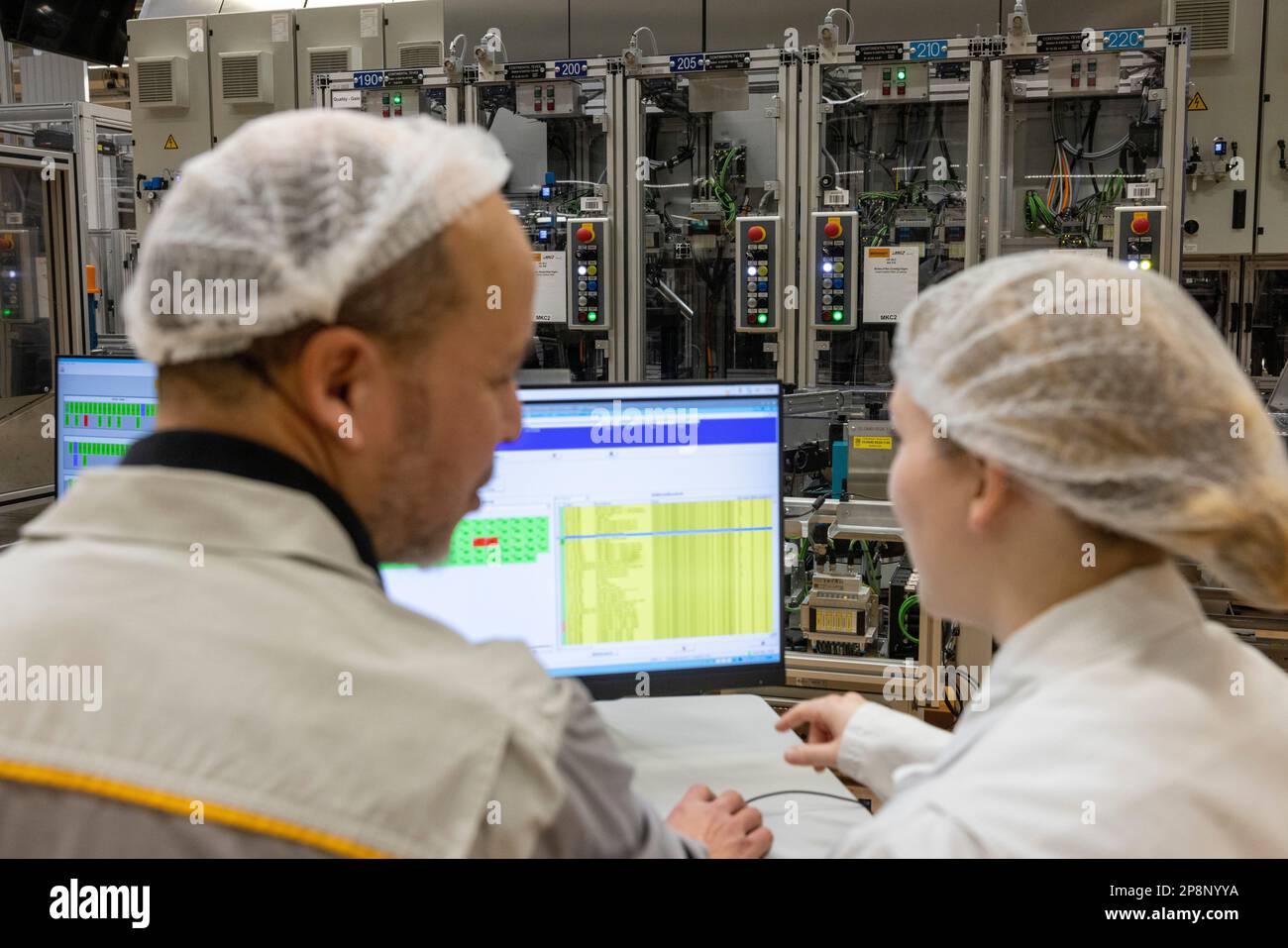 03 March 2023, Hesse, Frankfurt/Main: Continental employees look at a screen at the production site for MK C2 brake systems for the North American market. The MK C2 is Continental's second-generation brake-by-wire system. It went into series production in 2022. The system integrates the master cylinder, the brake booster and the control systems (ABS and ESC) in one module. Photo: Helmut Fricke/dpa Stock Photo