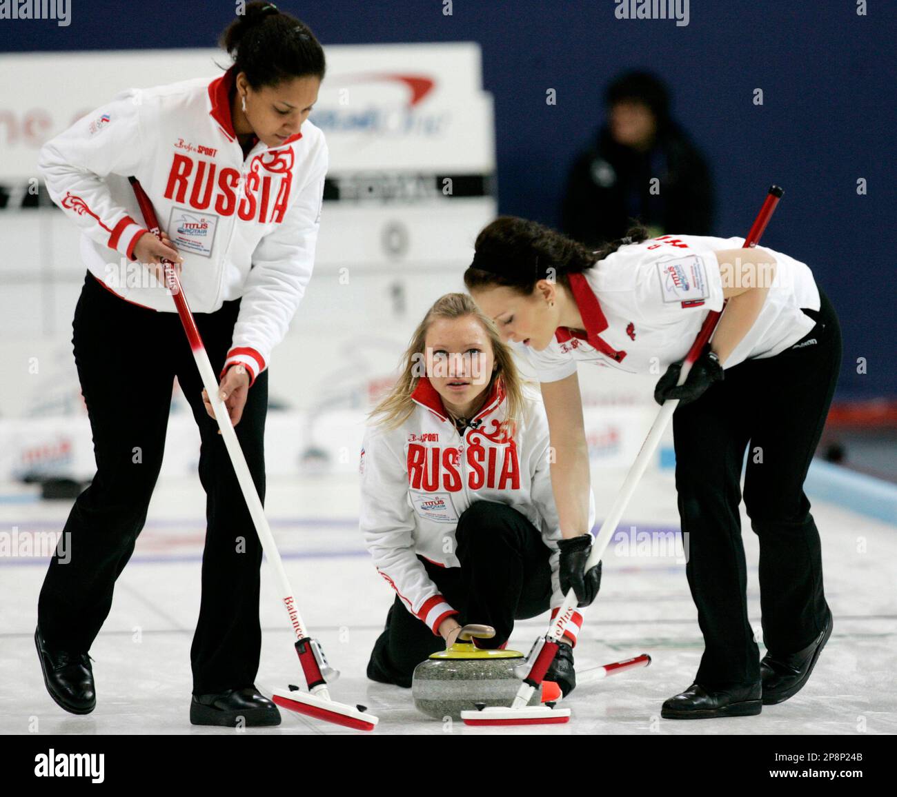 Russia's skip Liudmila Privivkova, center, releases a stone as her teammates Nkeiruka Ezekh and Ekaterina Galkina, right, sweep the path during their World Women's Curling Championships against Swedan in Gangneung, South Korea, Monday, March 23, 2009. (AP Photo/Ahn Young-joon) Stock Photo