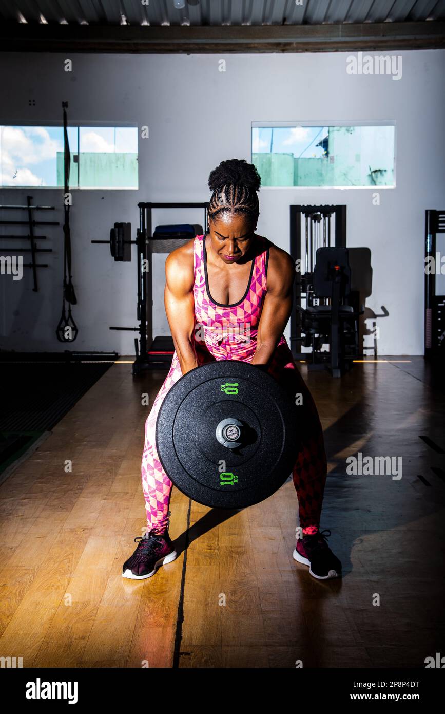 Muscular woman doing exercises with barbell in the gym. Crossfit