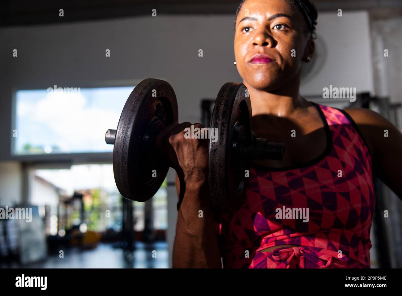 Dramatic portrait of fitness woman doing exercise for arm muscle. Gym training. Stock Photo