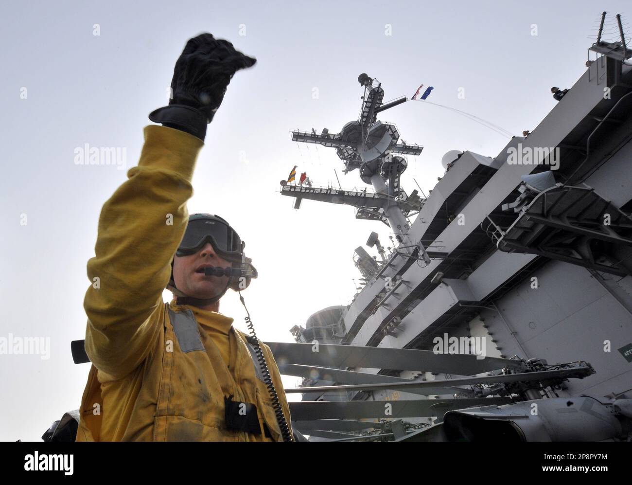 A U.S. Navy crew member gestures on the deck of the nuclear-powered