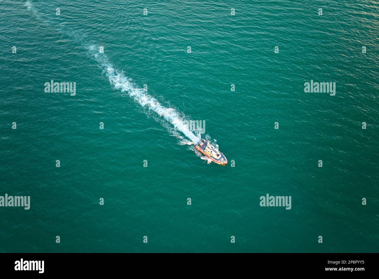 Aerial view of white yacht swimming on sea waves with ripple surface ...