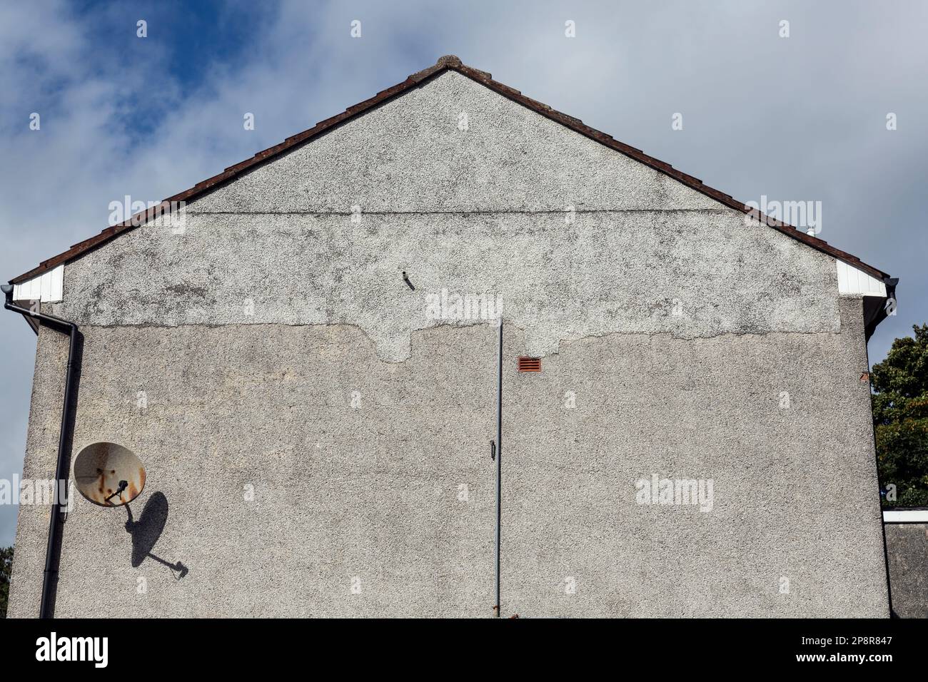 Damage to a previous roughcast repair on the gable of a house, Scotland