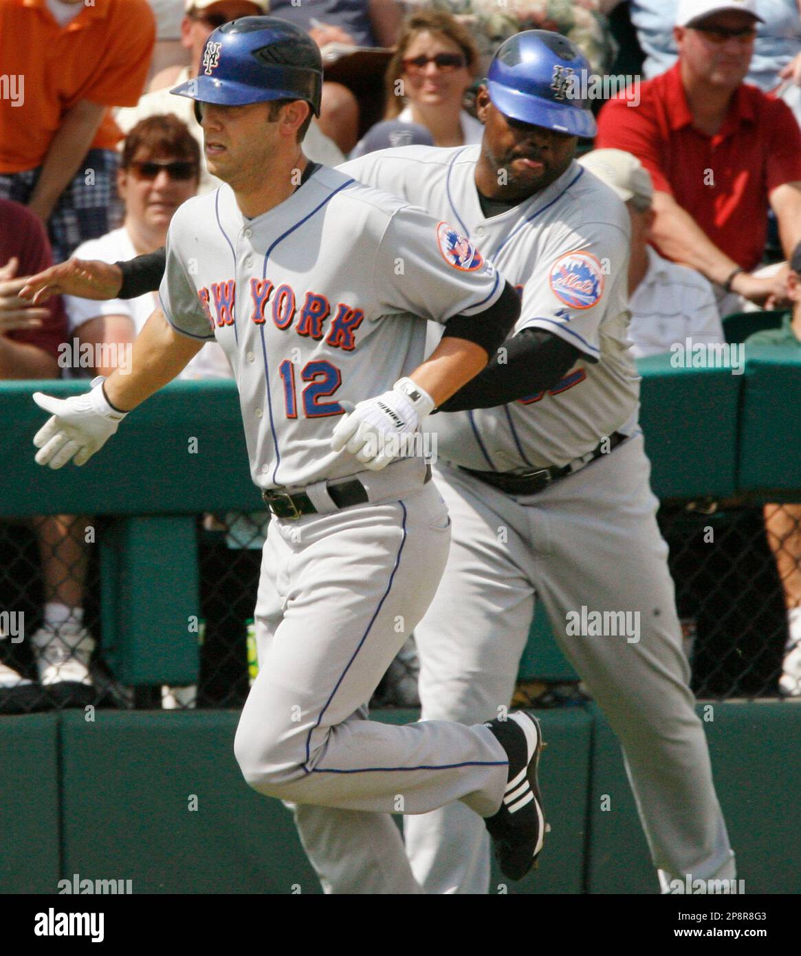 New York Mets' Cory Sullivan, left, is greeted by third base coach ...