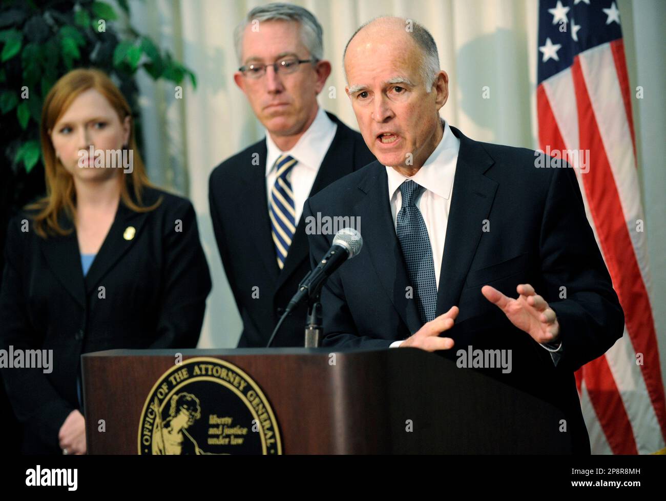 California Attorney General Jerry Brown, right, discusses charges filed