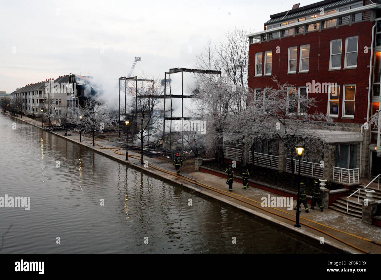 Members of the Indianapolis Fire Department walk near the remains of