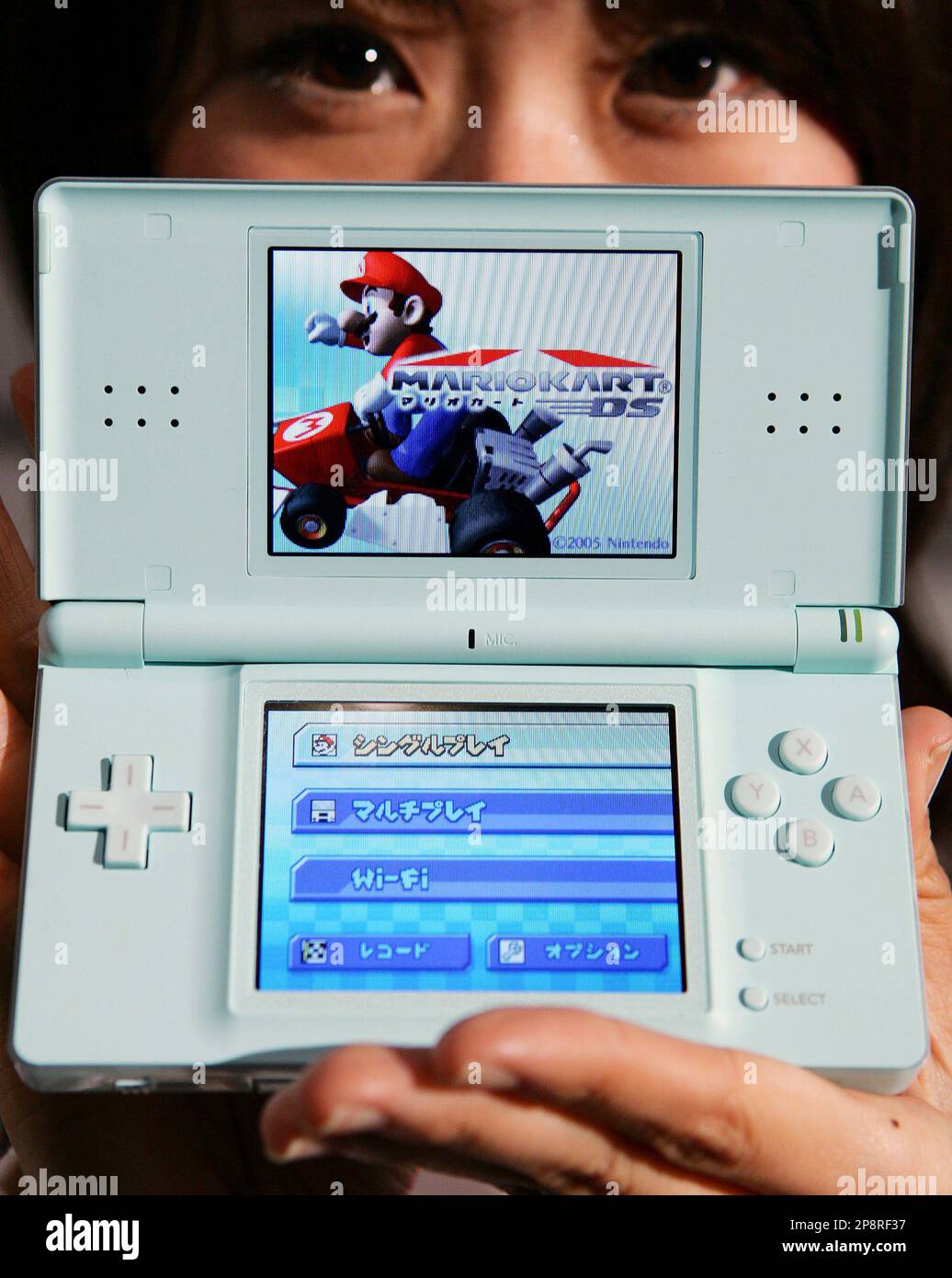 FILE ** In this Feb. 15, 2006 file photo, a model shows a new Nintendo DS  Lite handheld video-game machine during a news conference in Tokyo. Global  sales of the Nintendo