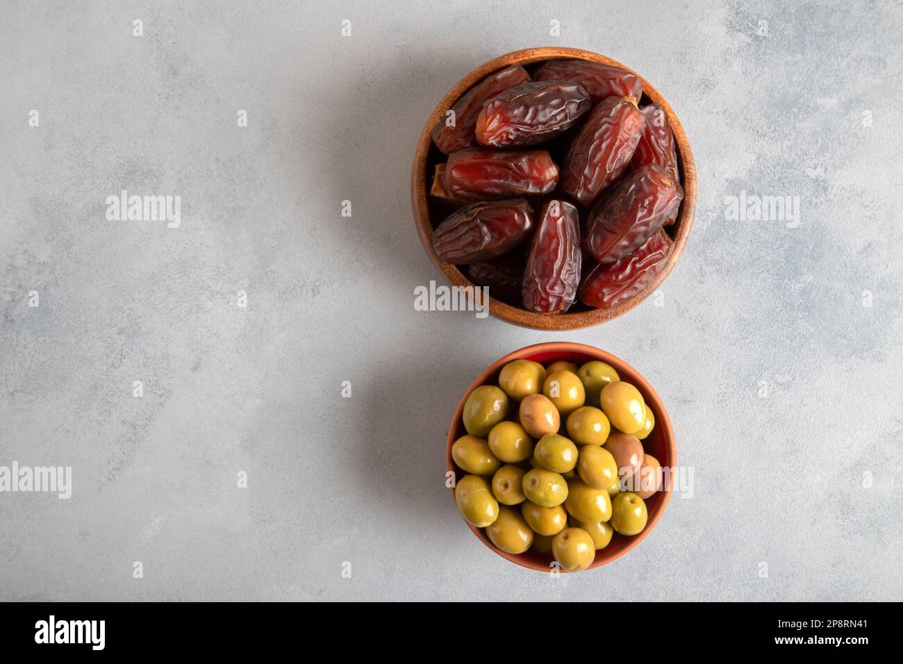 Date fruit with green olives on bright background, top view Stock Photo