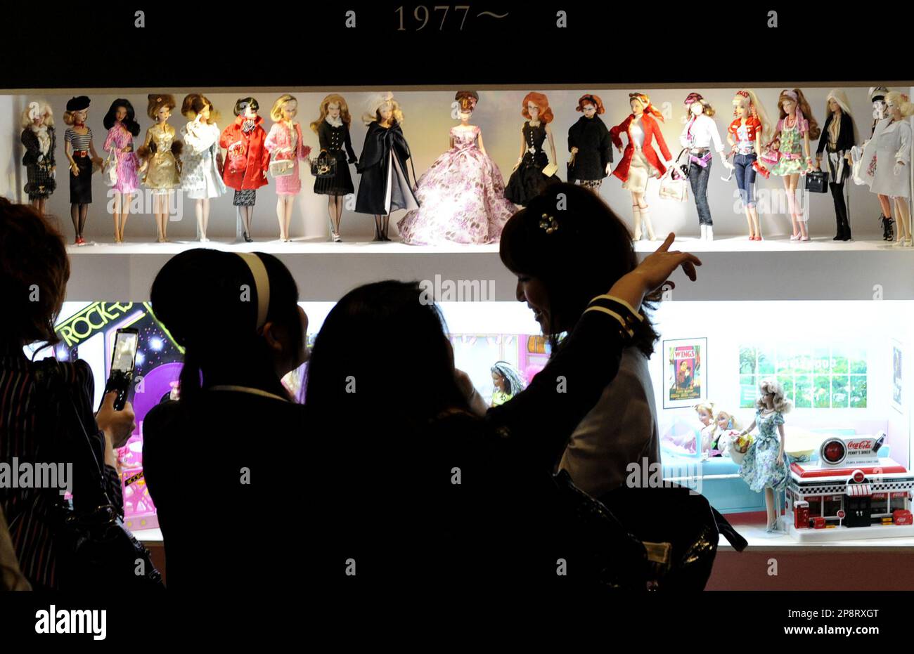 Vistors look at the latest lineup of Barbie dolls since 1977 during a