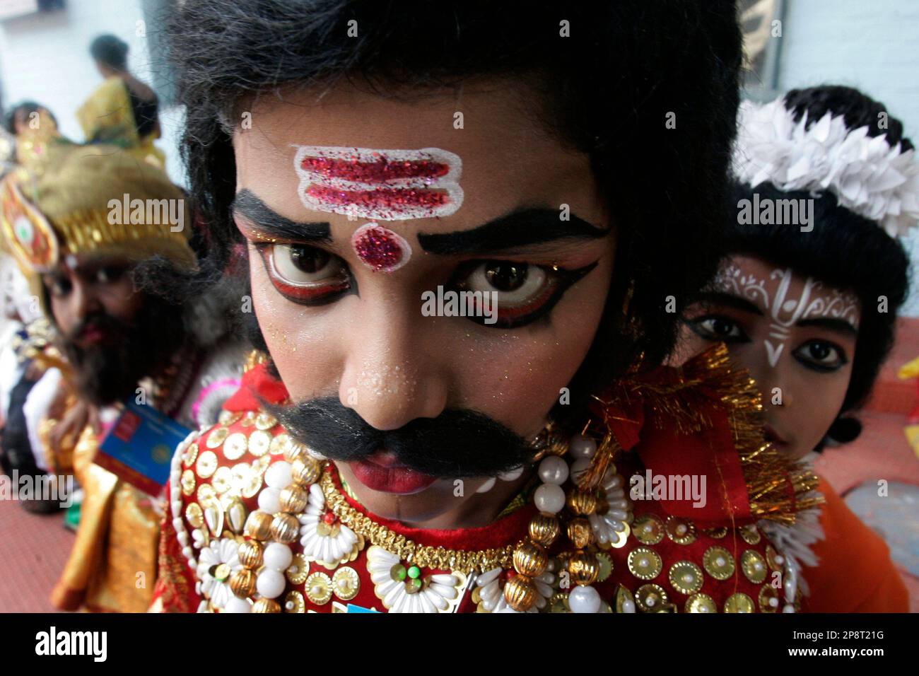 A student dressed as a Hindu mythological character Ravana looks on and