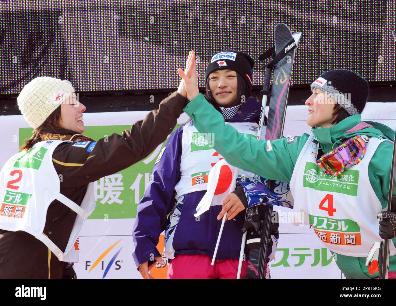 Winner Aiko Uemura of Japan, center, looks on as second-placed Jennifer Heil of Canada, left, and third-placed Nikola Sudova of Czech Republic, make high touch during the awarding ceremony for the women's moguls finals of the FIS Freestyle World Championships, in Inawashiro, Japan, Saturday, March 7, 2009. (AP Photo/Katsumi Kasahara) Stock Photo