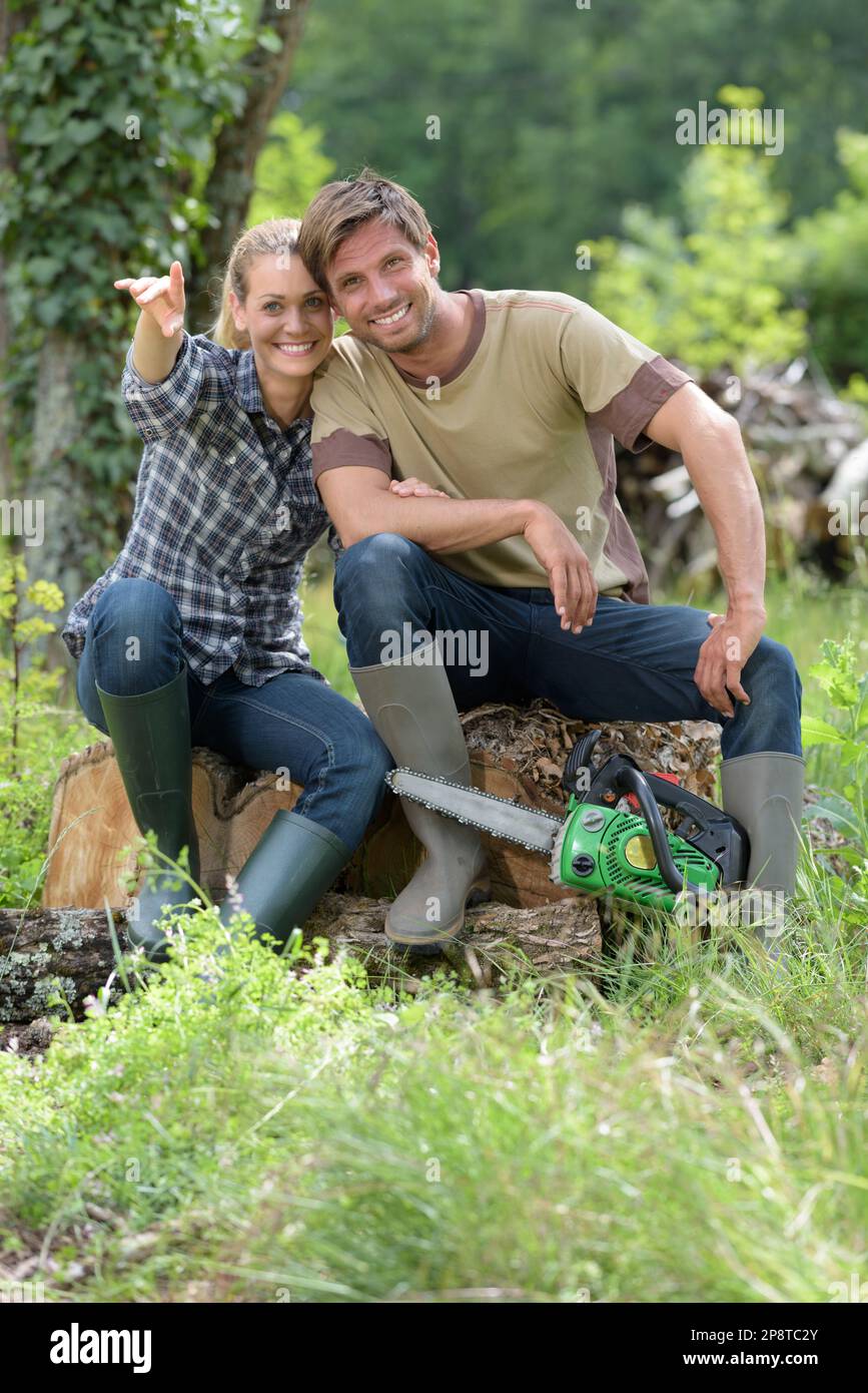 happy couple working with a chainsaw in the forest Stock Photo - Alamy