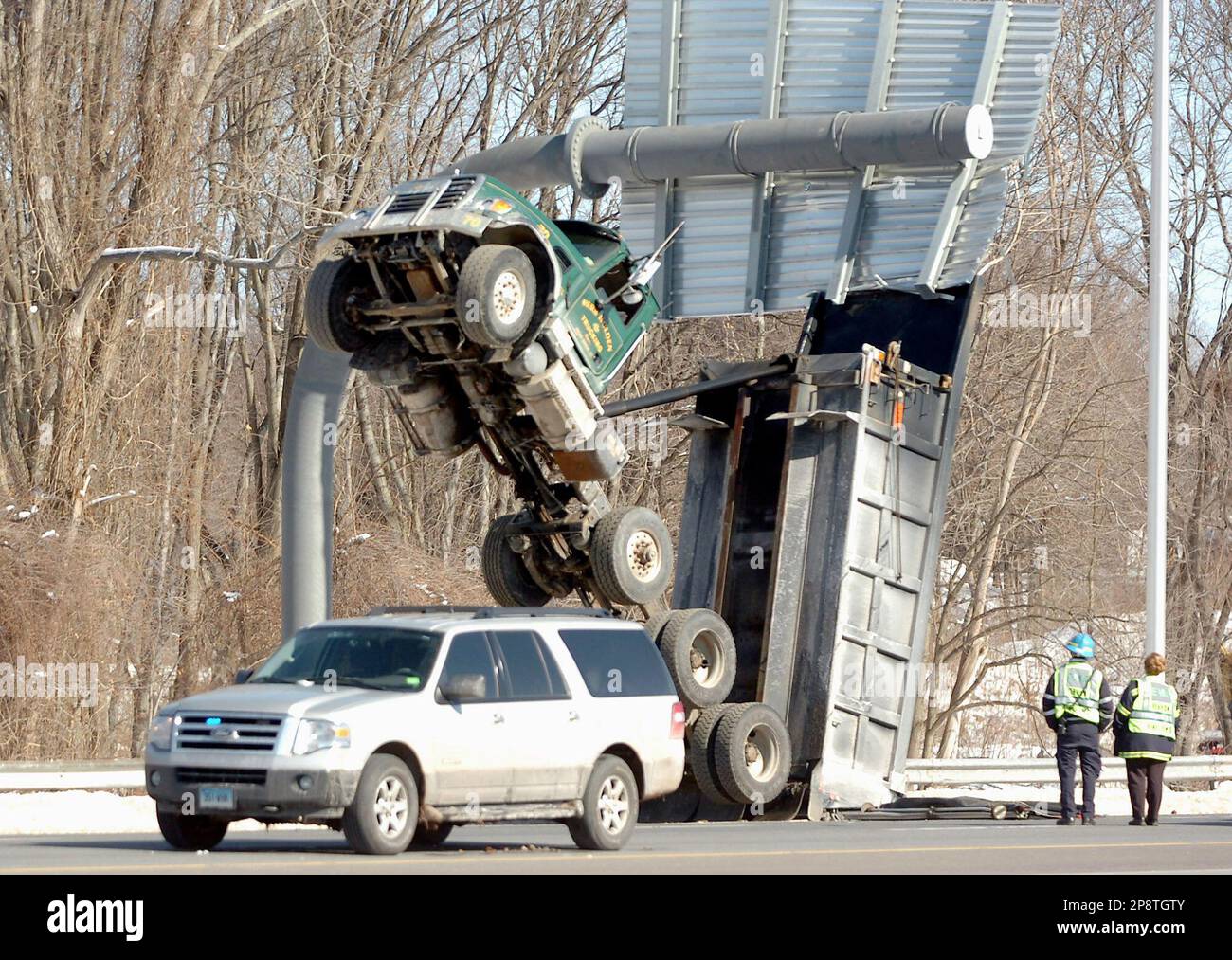 A dump truck sits on its tailgate after getting hung up and flipped  backwards at Exit 63 sign on Interstate 84 in Vernon , Conn., Wednesday,  March 4, 20009. State police say