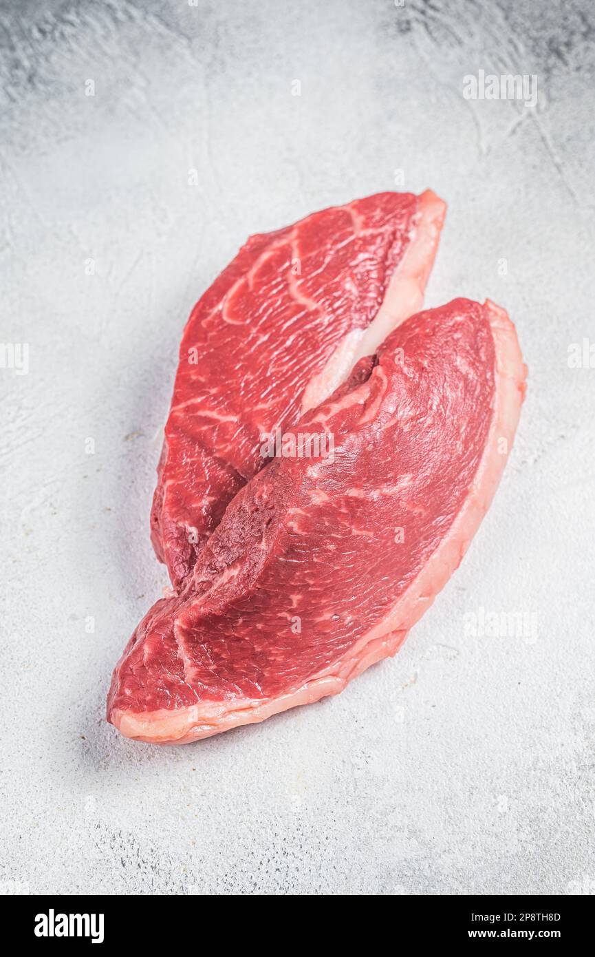 Raw top sirloin steak, cap rump beef meat steak. White background. Top view. Stock Photo