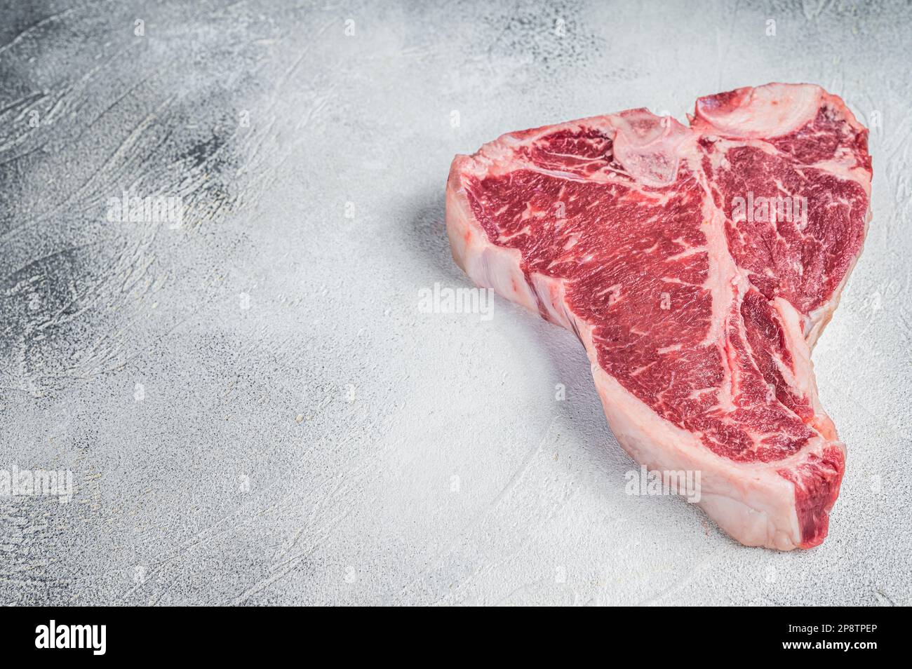 Porterhouse T-bone raw beef meat Steak. White background. Top view. Copy space. Stock Photo