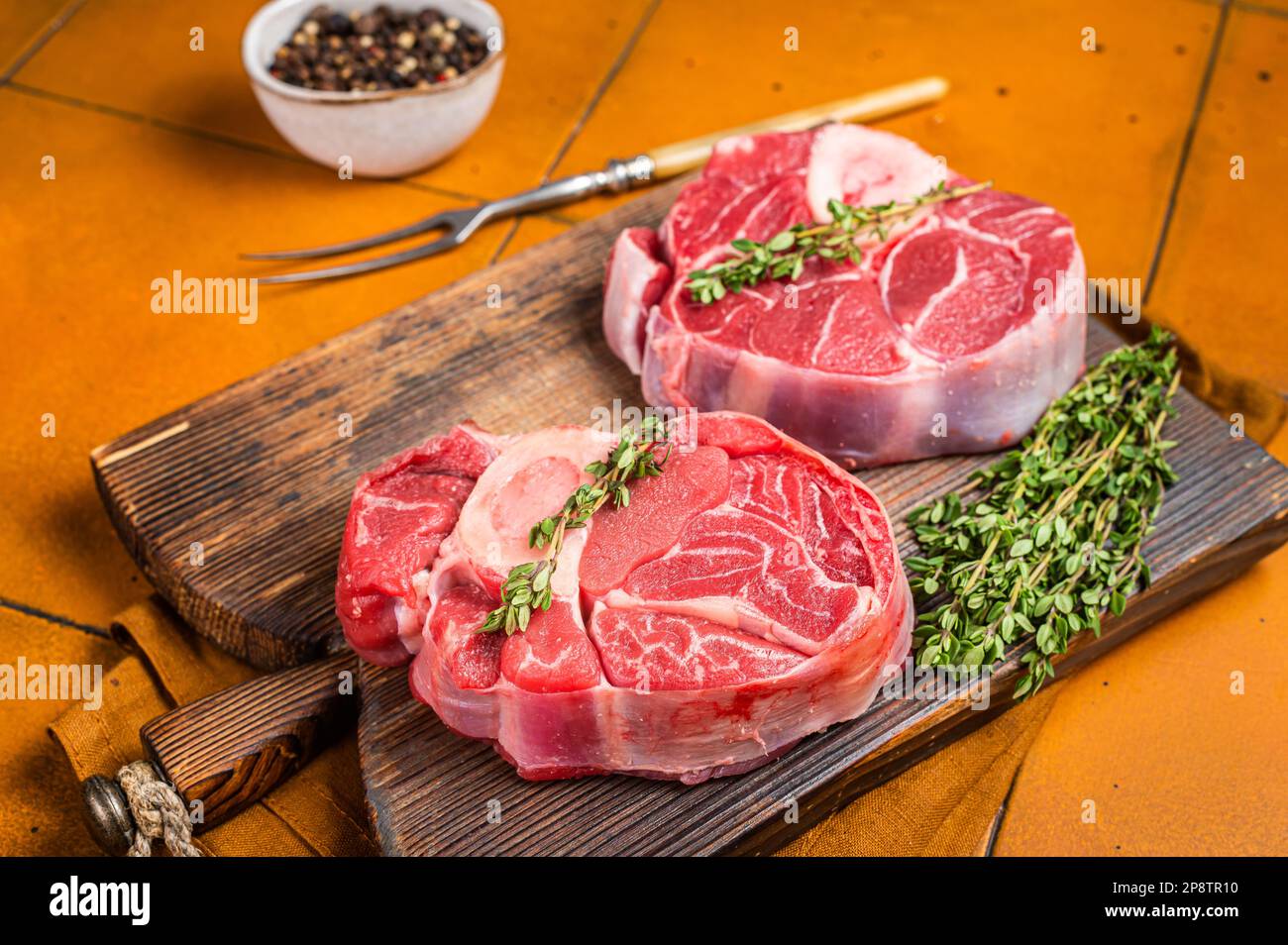 Osso buco Veal shank, raw cross cut veal shank, Italian Ossobuco. Orange background. Top view. Stock Photo