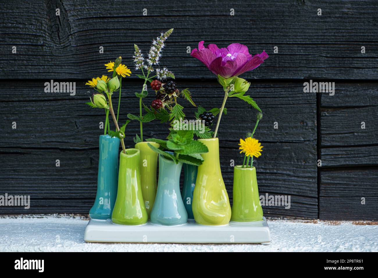 Small vases with blossoms with wooden background Stock Photo