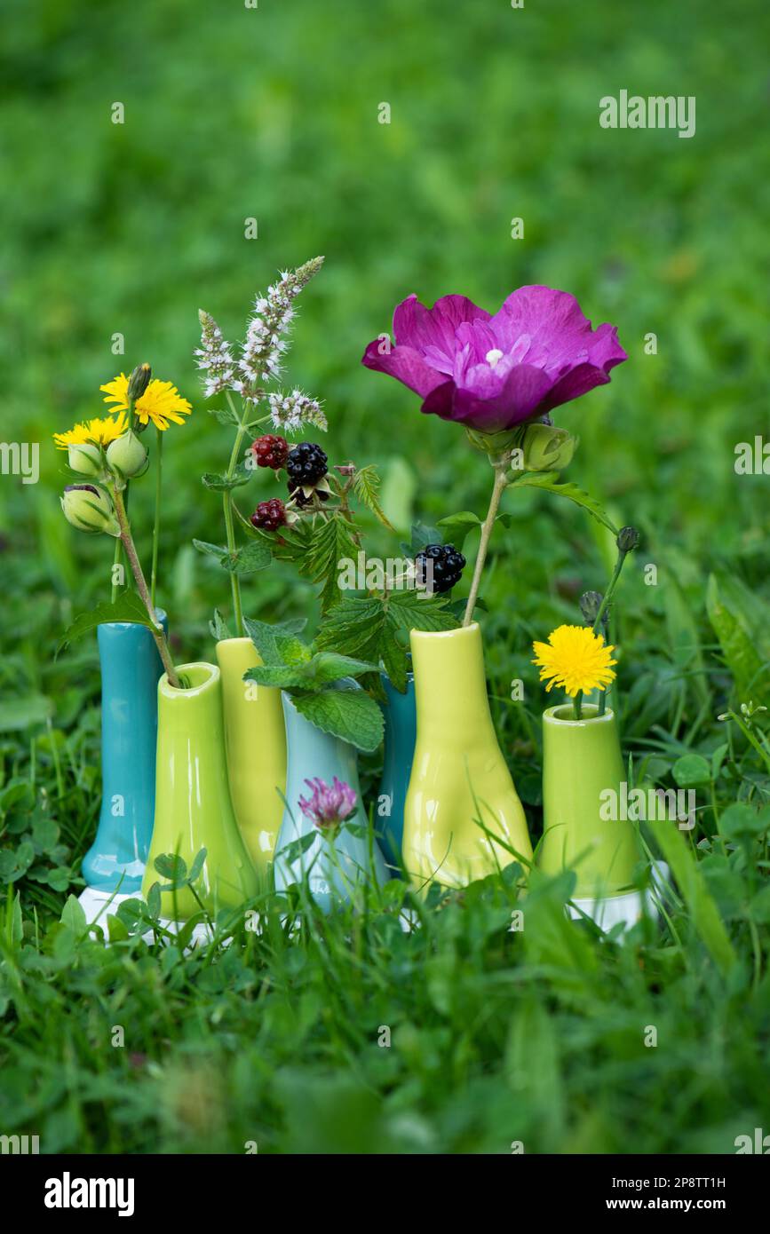 Small vases with blossoms with nature background Stock Photo