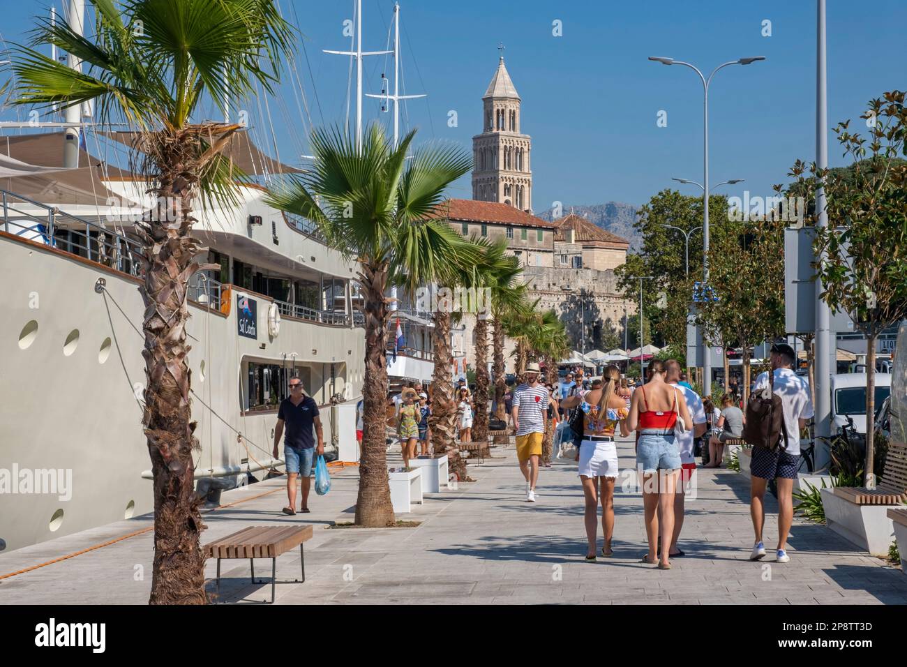 Romanesque bell tower of the Cathedral of St. Domnius and tourists visiting the port of the city Split, Split-Dalmatia County, Croatia Stock Photo