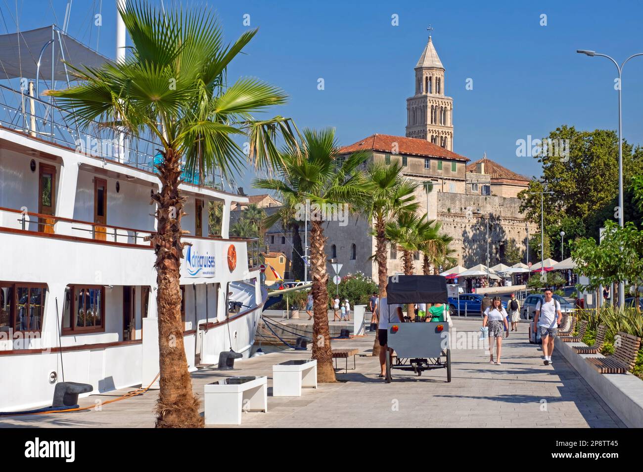 Romanesque bell tower of the Cathedral of St. Domnius and tourists visiting the port of the city Split, Split-Dalmatia County, Croatia Stock Photo