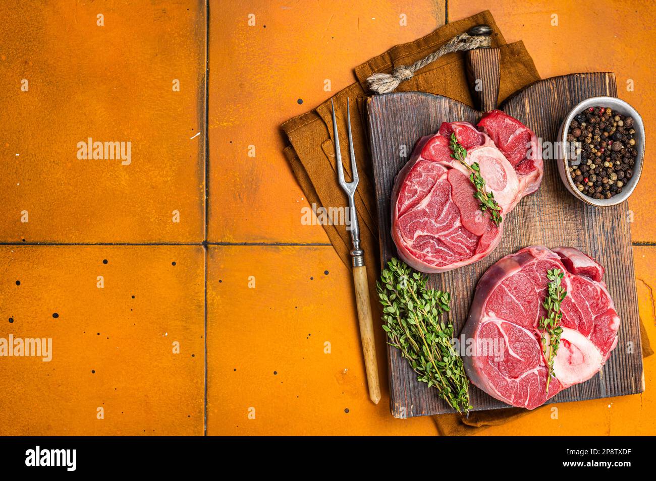 Osso buco Veal shank, raw cross cut veal shank, Italian Ossobuco. Orange background. Top view. Copy space. Stock Photo