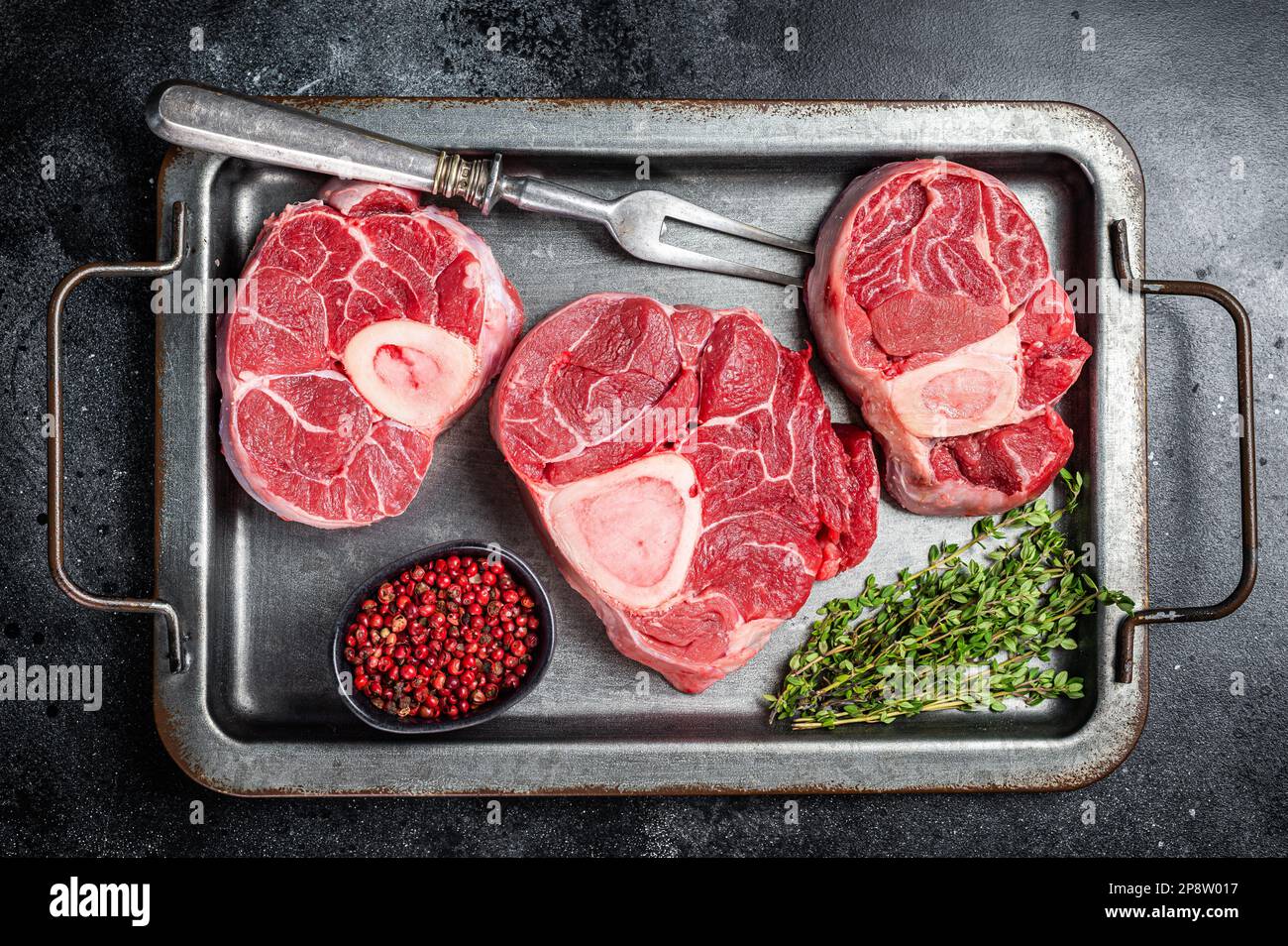 Fresh Raw Osso buco Veal steak, cross cut veal shank Ossobuco. Black background. Top view. Stock Photo