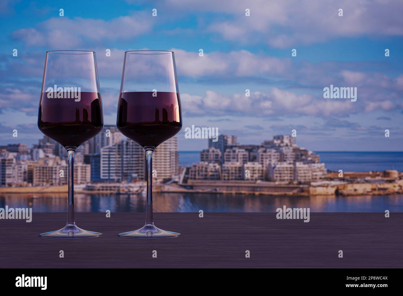 Glass of two red wine with view of Sliema harbor and skyscrapers in