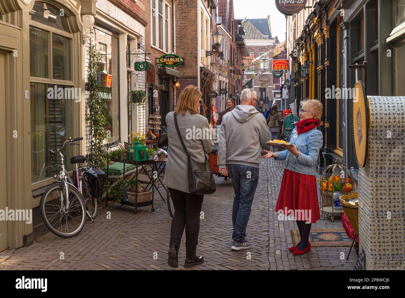 Cheese cubes are offered in a narrow cozy street in the center of Alkmaar. Stock Photo