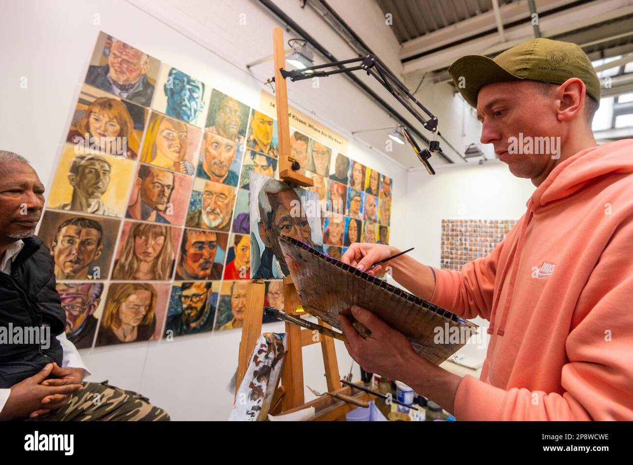 London, UK. 9 March 2023. (R) Portrait artist Rod Kitson paints at The