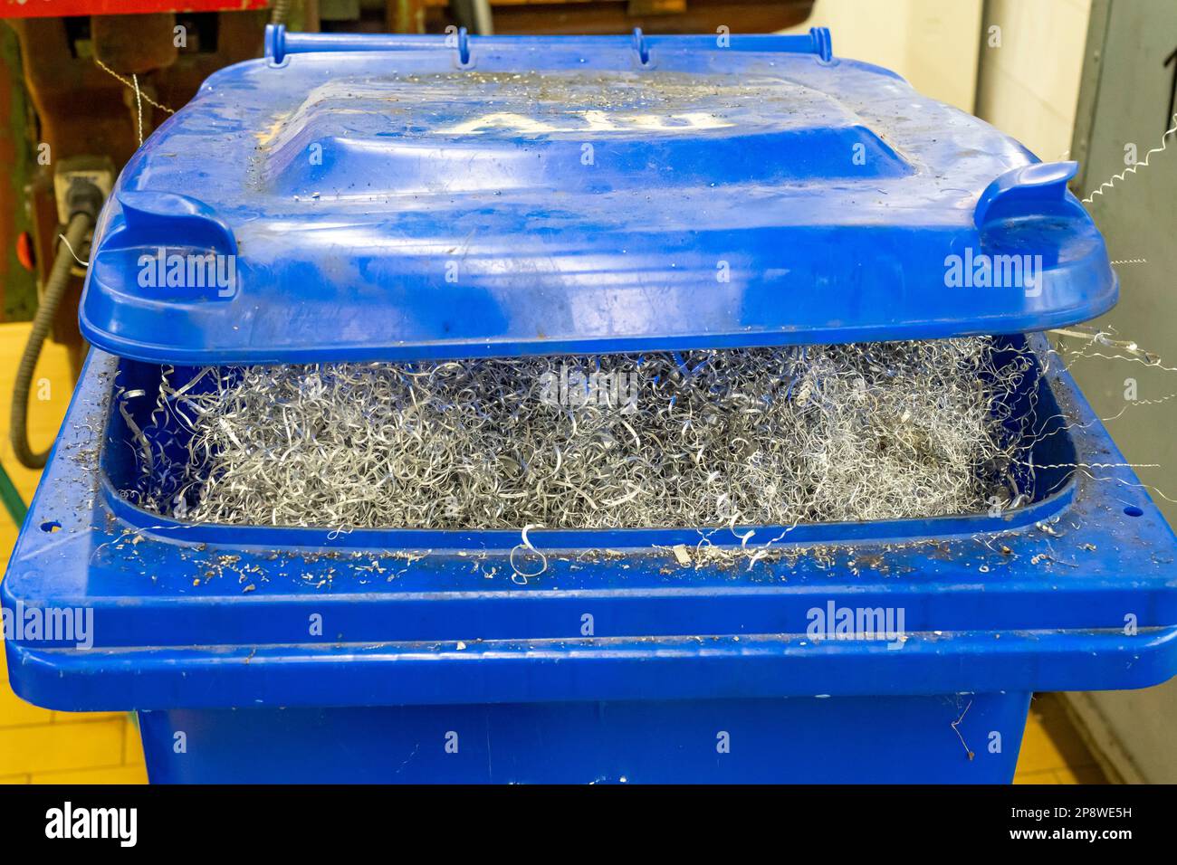 Silvercolored scrap metal collected in a blue bin Stock Photo Alamy