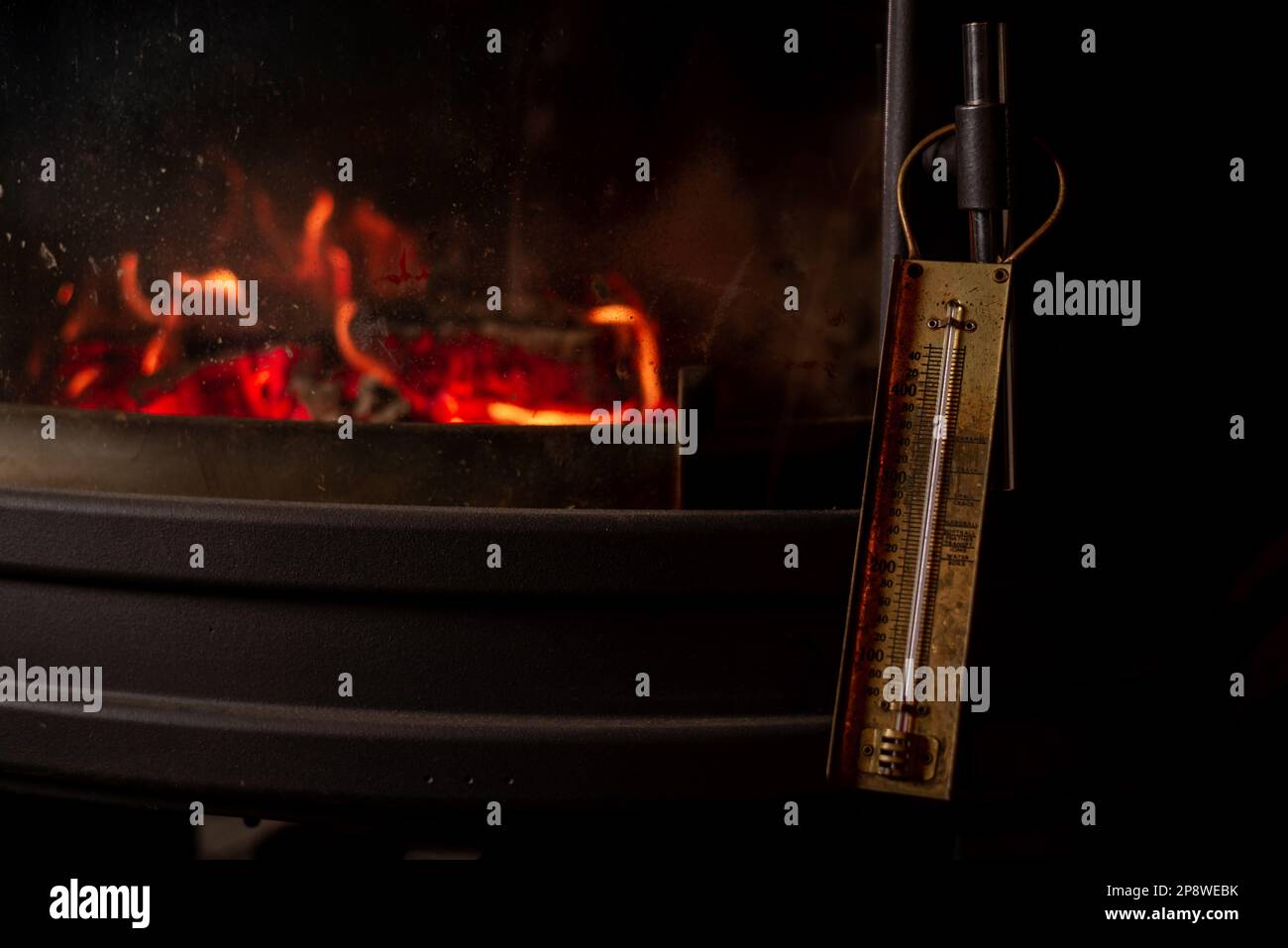 Burning fireplace and old thermometer. Heating temperature in room