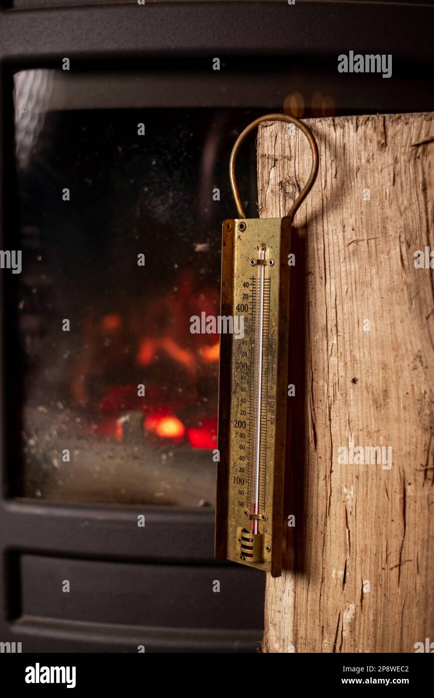 Burning fireplace and old thermometer. Heating temperature in room