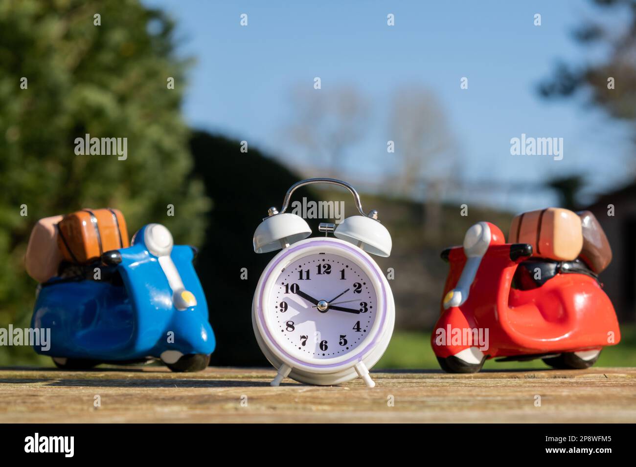 Toy scooters and alarm clock. Travel time. Fast concept delivery Stock Photo