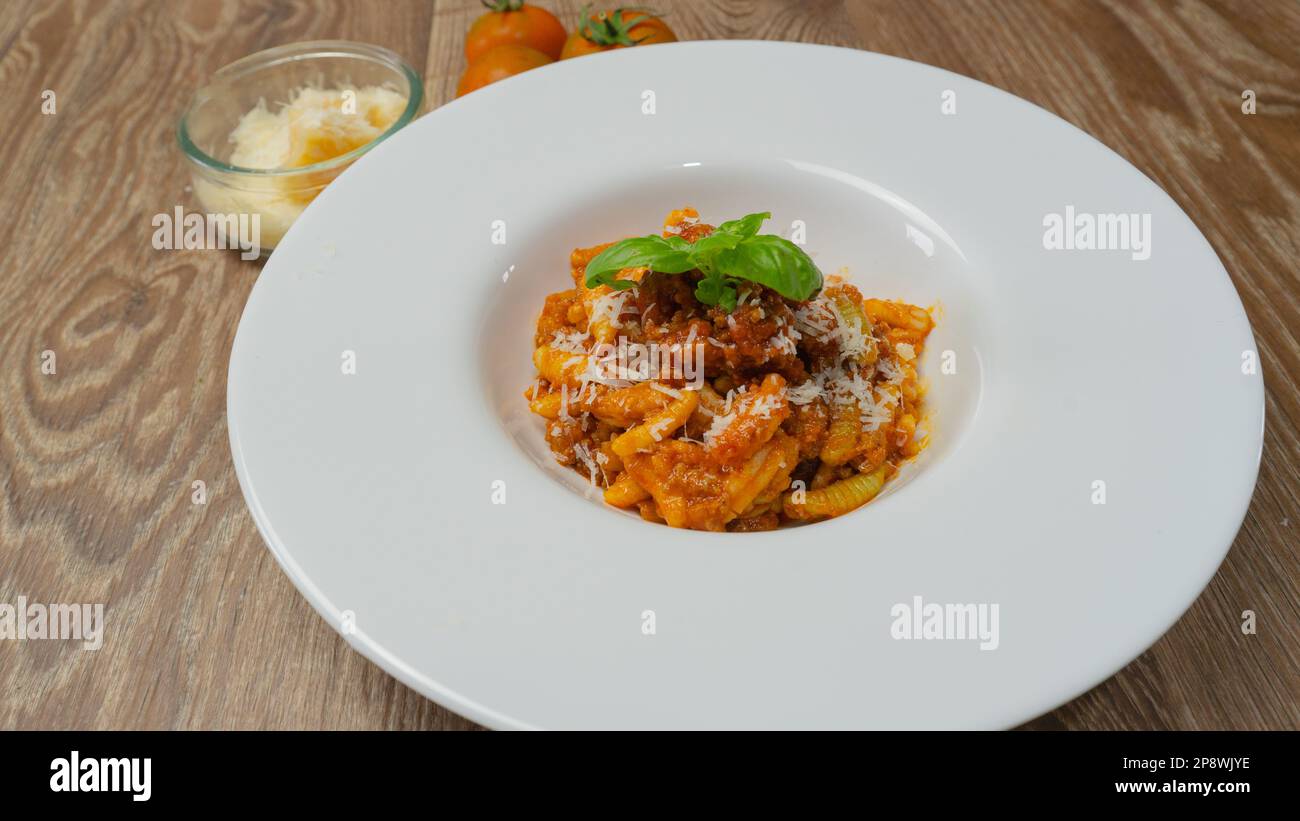 malloreddus or Sardinian gnocchetti, typical Sardinian pasta, with wild boar sauce, basil and pecorino cheese Stock Photo