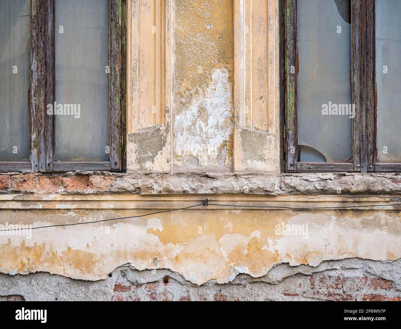 Detail with an old worn out building. Plaster peeling from an old brick