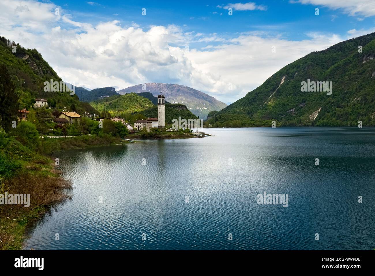 The lake of Corlo and the bell tower of the village of Rocca. Arsié, Belluno province, Veneto, Italy. Stock Photo