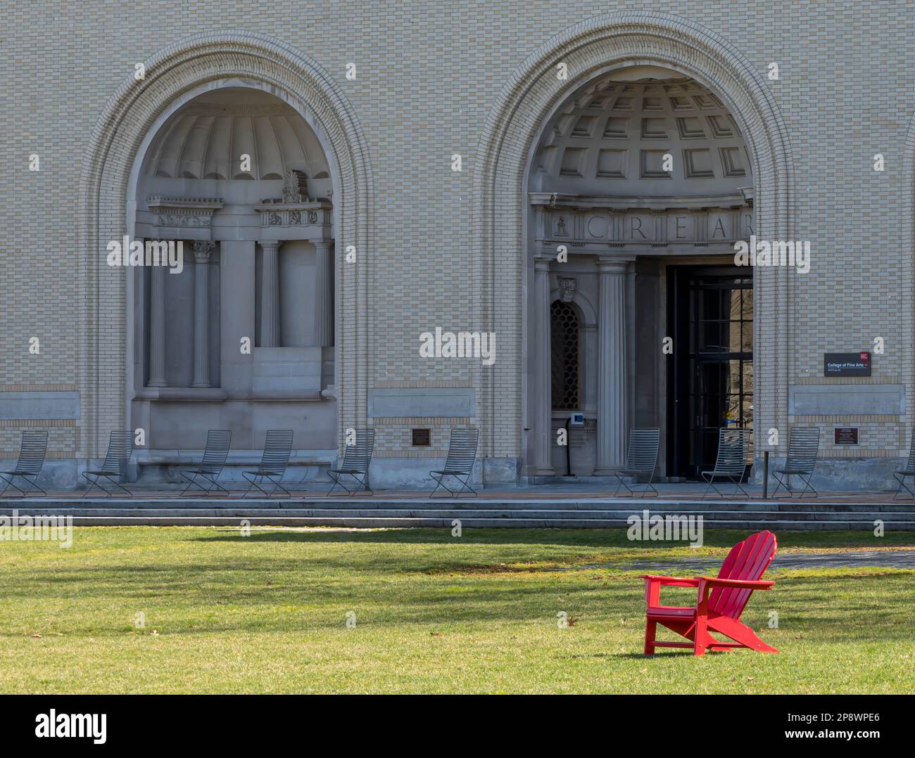 A single adirondack chair in front of a building on the Carnegie Mellon University campus in