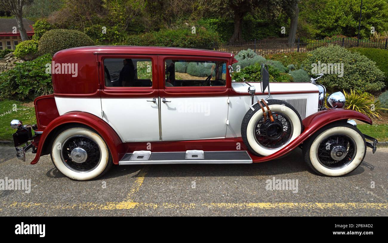FELIXSTOWE, SUFFOLK, ENGLAND - MAY 01, 2022:  Classic Red and Cream Nash Ambassador Motor Car isolated in front of Gardens. Stock Photo