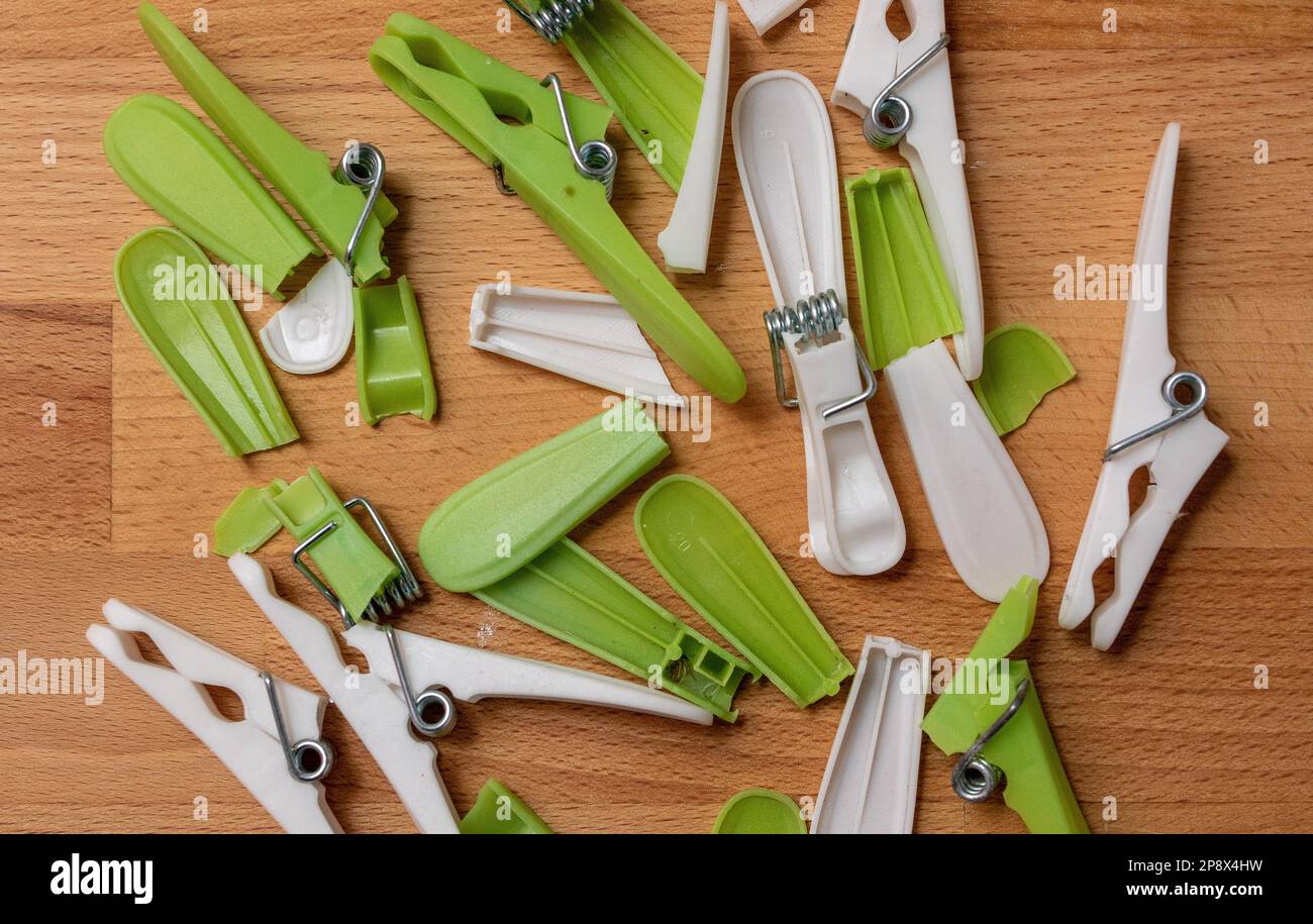 Broken cheap plastic clothes pegs that keep breaking with little use Stock Photo